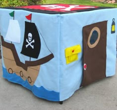 a toy box with a pirate theme on the front and side, is sitting outside