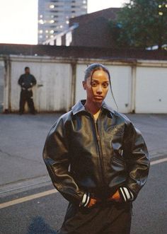 a man standing on the street wearing a black leather jacket