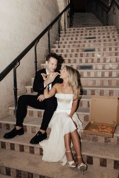 a man in a tuxedo and a woman in a wedding dress sitting on some stairs