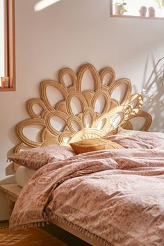 a bed with a wooden headboard sitting next to a window