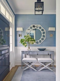 a blue and white room with a mirror on the wall