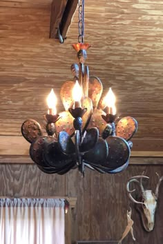 a chandelier hanging from the ceiling in a room with wood paneled walls