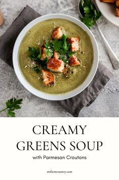 creamy green soup with parmesan croutons in a white bowl on a gray table