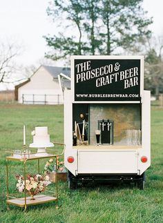 an old fashioned ice cream cart is set up in the grass for a wedding reception