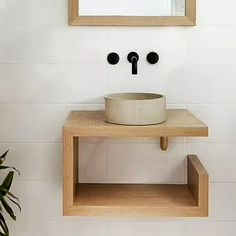 a bathroom with a sink, mirror and plant on the counter top in front of it