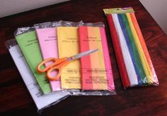 a pair of scissors sitting on top of some colored napkins next to each other