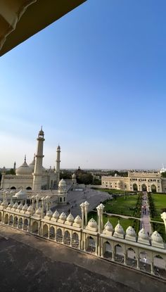 the view from inside an ornate building looking down on a large lawn and buildings in the distance