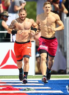 two shirtless men running on a race track