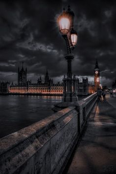 the big ben clock tower towering over the city of london at night with dark clouds