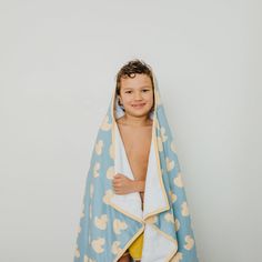 a young boy wrapped in a blue and yellow duck print bathrobe, smiling at the camera