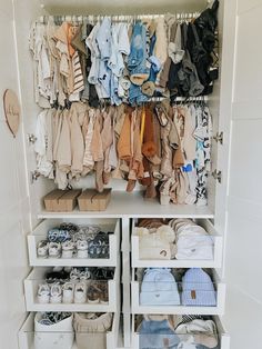 a closet filled with lots of baby clothes and shoes next to a wall mounted shelf