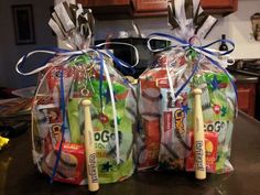 two plastic bags with baseballs and bats in them sitting on a kitchen counter top