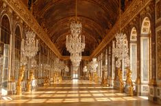 an ornate hall with chandeliers and mirrors on the walls is shown in gold