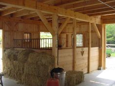 the inside of a barn with hay bales