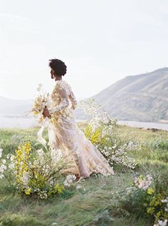 a woman in a dress is walking through the grass