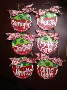 christmas ornaments are hanging on the wall in front of a brown table with red and green decorations