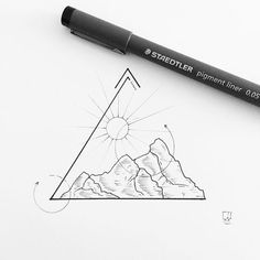 a pen is sitting on top of a piece of paper next to a drawing of a mountain