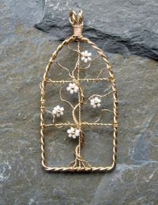 a wire and glass birdcage with flowers on it sitting on top of a rock