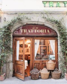 a store front with baskets in front of it and ivy growing on the outside wall