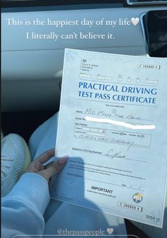 a person holding up a driving test certificate