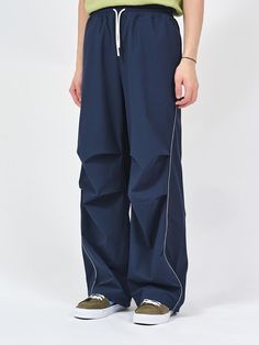 These are semi-wide fit curved piping pants made of nylon spandex ribstop fabric for a comfortable fit. It is accentuated with a reflective piping on the curved line from the waistline to the hem, and a three-dimensional silhouette is added with the tuck detail at the knee. - Semi-wide fit- Piping detail- Adjustable string on hem- Spoty mood Piping Pants, Blue Pants Men, Navy Blue Pants, Curves Workout, Three Dimensional, Track Pants, Piping, The Knee, Navy And White