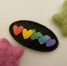 two small felt hearts are next to each other