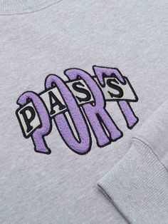 a grey sweatshirt with the word paris printed on it's chest and purple letters