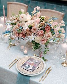 the table is set with flowers and candles