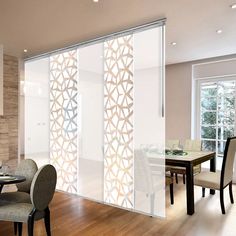 a dining room table with chairs and a sliding glass door that has an intricate design on it