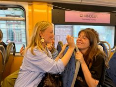 two women sitting on a bus and smiling