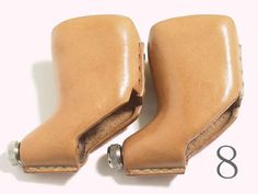 pair of tan leather booties with metal fittings on each side and the number 8