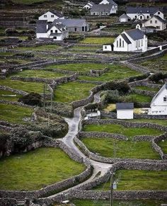 a small village in the middle of a grassy field with houses on top of it