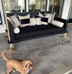 a dog is standing in front of a porch swing with pillows and cushions on it