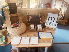 there is a table with books and pictures on it in the middle of a room