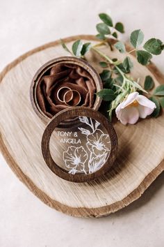 two wedding rings sitting on top of a wooden ring box