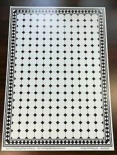 a black and white tile pattern on a wooden table