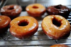 several glazed donuts are cooling on a rack