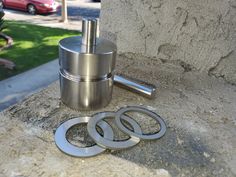 a couple of metal rings sitting on top of a cement wall next to a red car