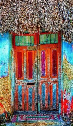 an old building with two doors and a thatch roof on it's side