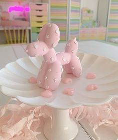 a pink balloon dog on a white cake plate