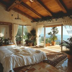 a large bed sitting inside of a bedroom next to a sliding glass door with an ocean view