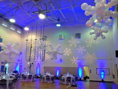 an indoor banquet hall decorated with snowflakes and balloons