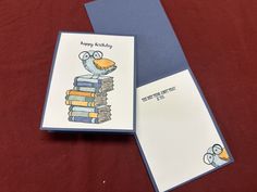 a card with an image of a bird sitting on top of a stack of books