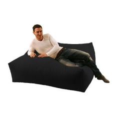 a man sitting on top of a black bean bag chair