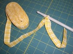 a pair of scissors sitting on top of a cutting board next to a yellow ribbon