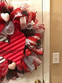 a valentine's day heart wreath on a door with the word love written on it