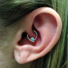 a close up of a person's ear with a ring on top of it