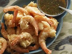 a blue plate topped with shrimp and dipping sauce