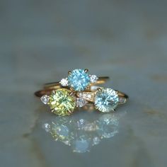 three different colored diamonds on top of each other in yellow gold and white gold rings