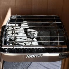 a toaster oven sitting on top of a table next to a wall with rocks in it